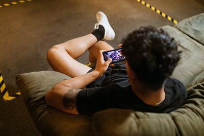 man on sofa gaming on mobile